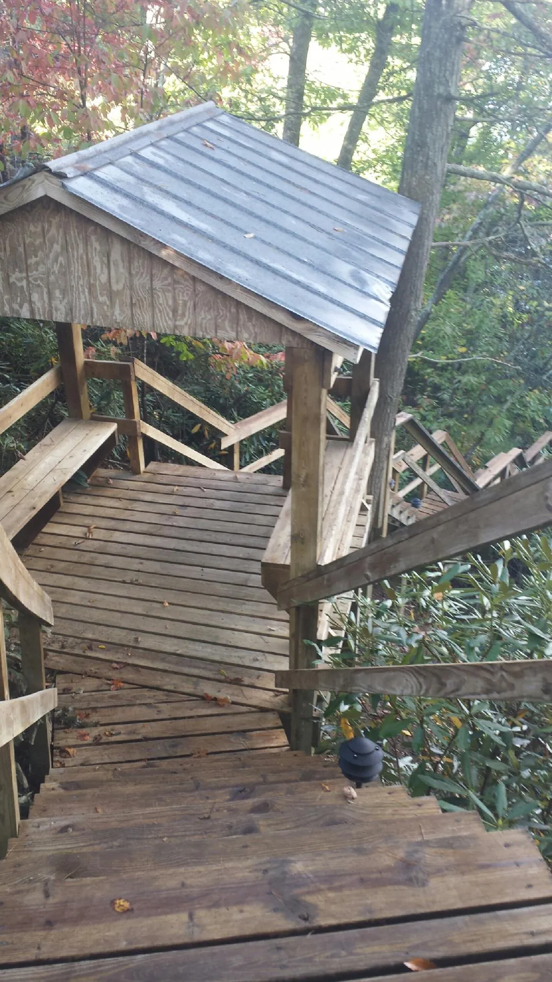 Metal roofed shelter over wooden steps on a wooded walkway — Skylight Repair & Installation work by our crew in Thomaston