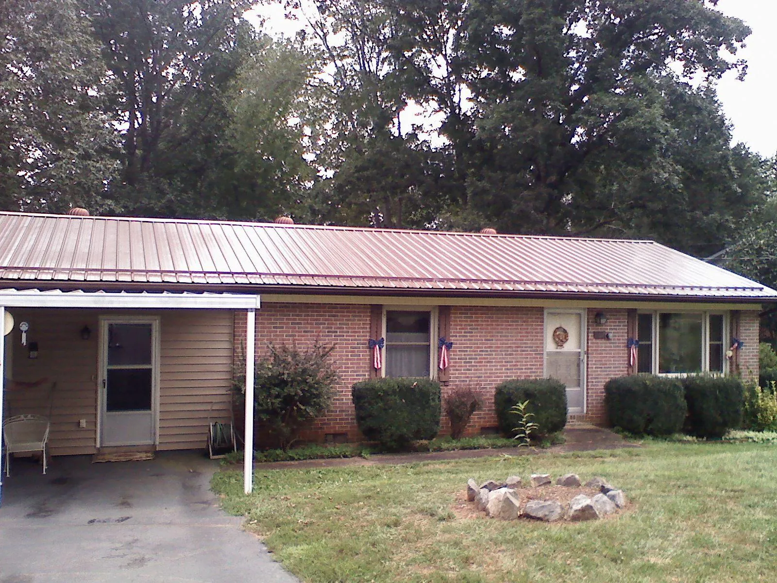 Bronze metal roof and carport on a brick ranch home — Roof Repair work by our crew in Thomaston